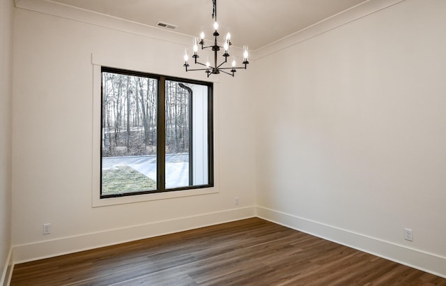 unfurnished dining area featuring crown molding, dark hardwood / wood-style floors, and an inviting chandelier