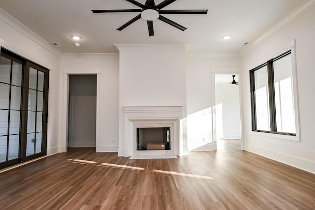 unfurnished living room featuring hardwood / wood-style flooring, ceiling fan, and crown molding