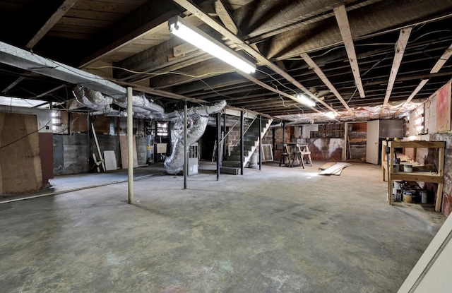 unfinished basement with water heater and stairs