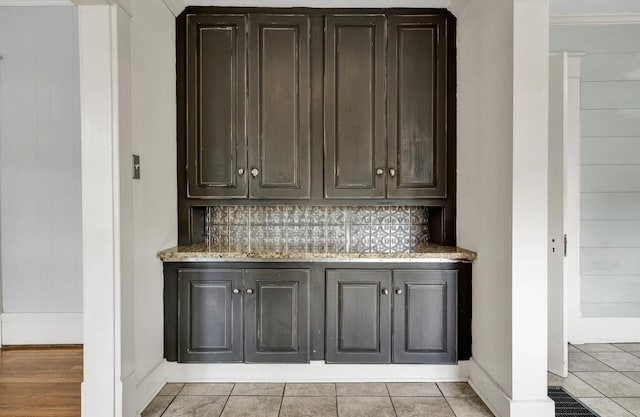 bar with baseboards, backsplash, and light tile patterned floors