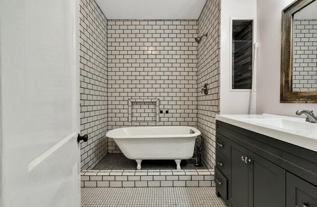 bathroom with vanity, tile patterned flooring, a freestanding bath, and tiled shower