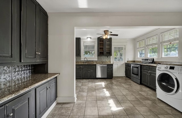 interior space featuring dark stone counters, tasteful backsplash, ceiling fan, appliances with stainless steel finishes, and washer / clothes dryer