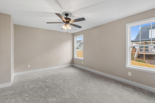 spare room with plenty of natural light, ceiling fan, and carpet floors