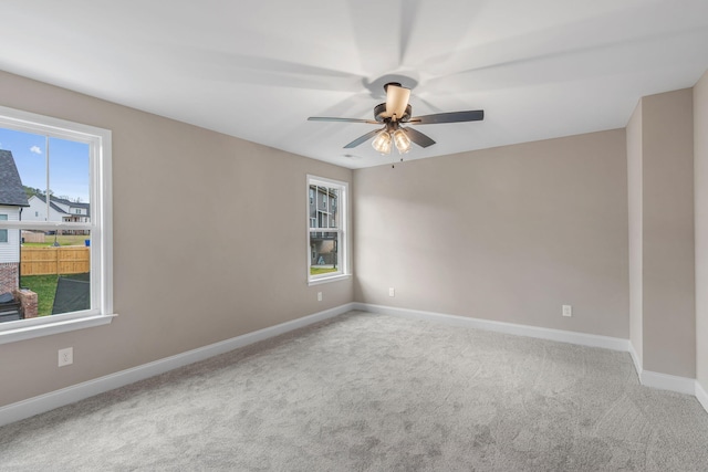 carpeted spare room featuring ceiling fan