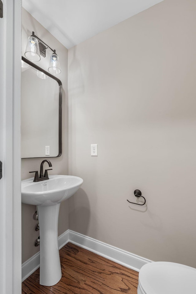 bathroom with toilet and wood-type flooring