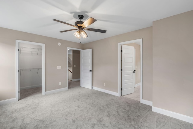 unfurnished bedroom with ceiling fan, a closet, and light carpet