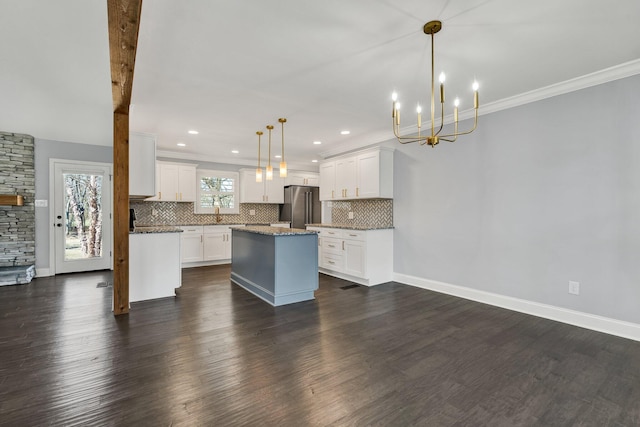 kitchen featuring dark wood-style flooring, high end refrigerator, white cabinets, a center island, and decorative light fixtures