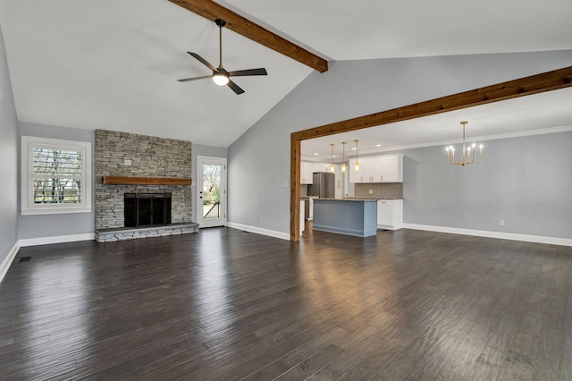 unfurnished living room featuring ceiling fan with notable chandelier, a stone fireplace, beamed ceiling, and a healthy amount of sunlight