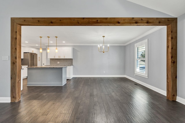unfurnished living room with baseboards, crown molding, dark wood finished floors, and a notable chandelier