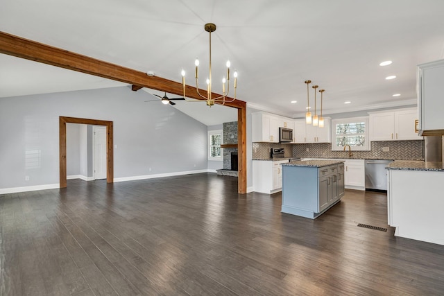 kitchen featuring white cabinets, a kitchen island, pendant lighting, and open floor plan