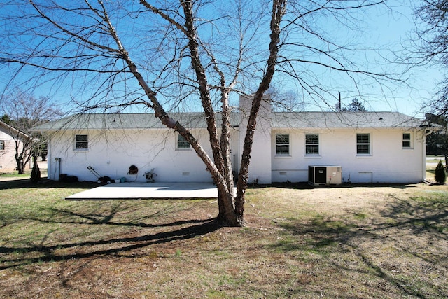rear view of property featuring cooling unit, brick siding, crawl space, a lawn, and a patio area