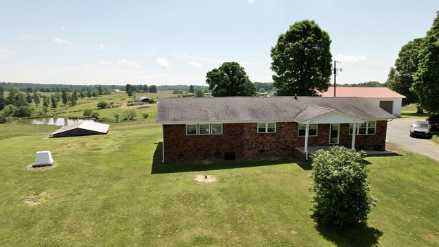 view of front of property featuring a front lawn and a water view