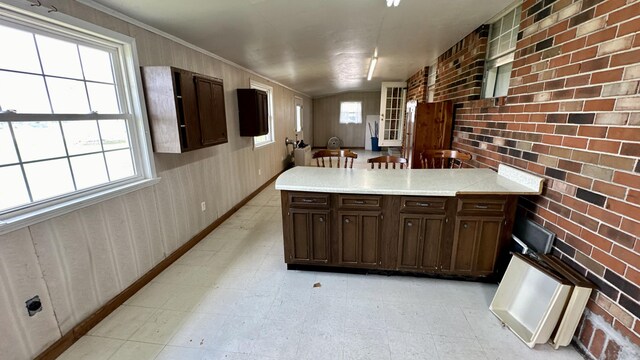 kitchen with dark brown cabinets and brick wall