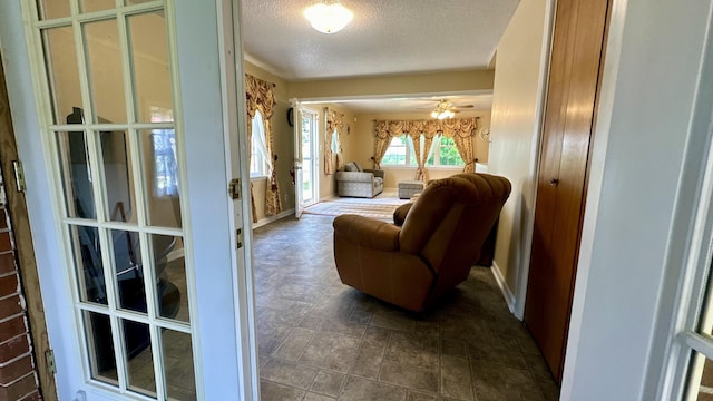 sitting room with ceiling fan and a textured ceiling