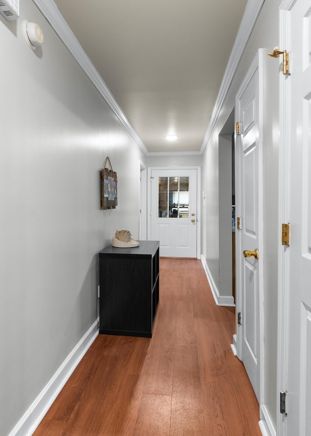 corridor with wood-type flooring and ornamental molding