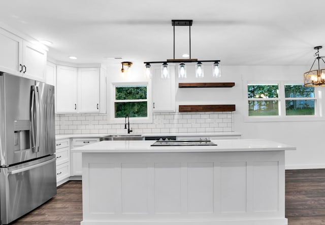 kitchen featuring a center island, stainless steel fridge with ice dispenser, sink, and white cabinetry