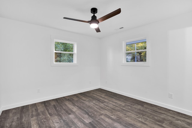 spare room with ceiling fan, a healthy amount of sunlight, and dark hardwood / wood-style flooring