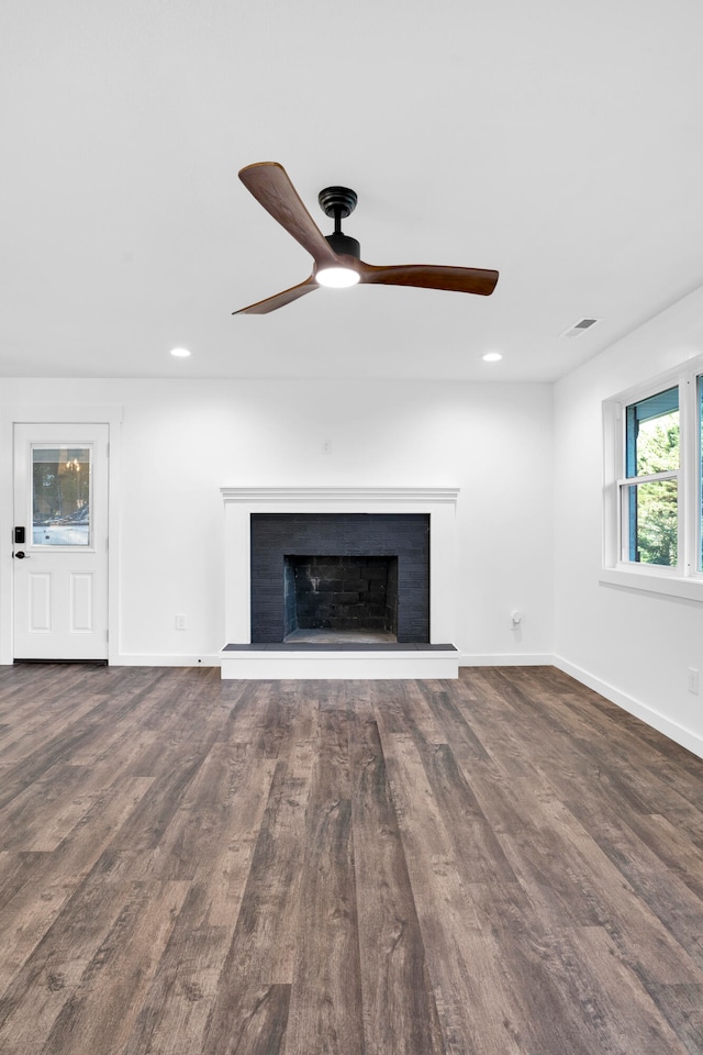 unfurnished living room featuring ceiling fan and dark wood-type flooring