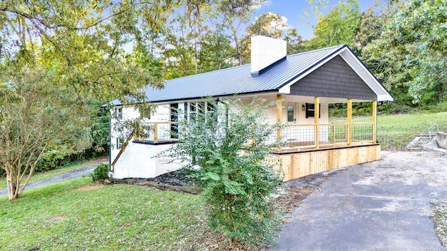 view of property exterior with a yard and covered porch