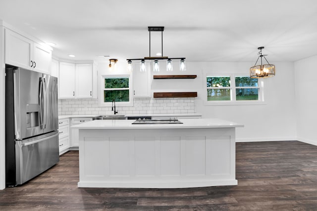 kitchen featuring stainless steel fridge with ice dispenser, white cabinetry, a kitchen island, and pendant lighting