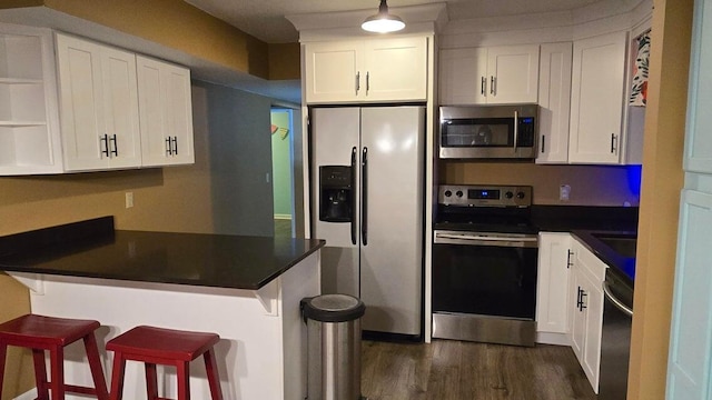 kitchen with white cabinetry, stainless steel appliances, and kitchen peninsula