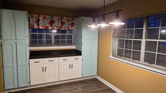 kitchen featuring decorative light fixtures, dark wood-type flooring, and white cabinets