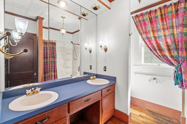 bathroom with crown molding, hardwood / wood-style floors, vanity, and walk in shower