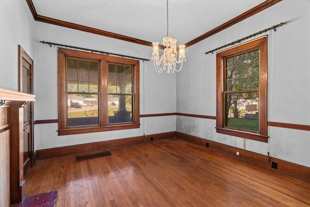 unfurnished dining area with ornamental molding, wood-type flooring, and a notable chandelier