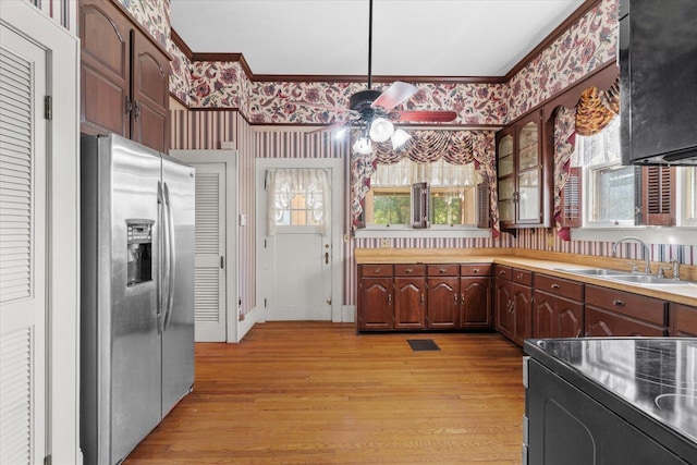 kitchen featuring ceiling fan, sink, electric range oven, stainless steel fridge, and light hardwood / wood-style floors