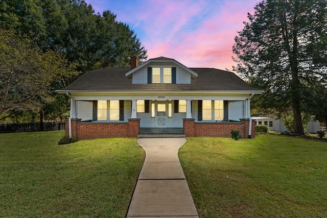 bungalow featuring a porch and a yard