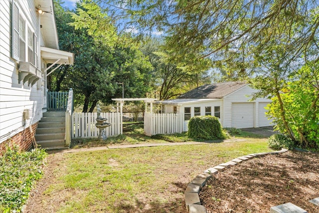 view of yard with a garage and an outbuilding