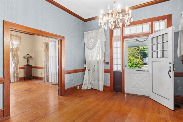 entryway with light wood-type flooring, an inviting chandelier, and crown molding