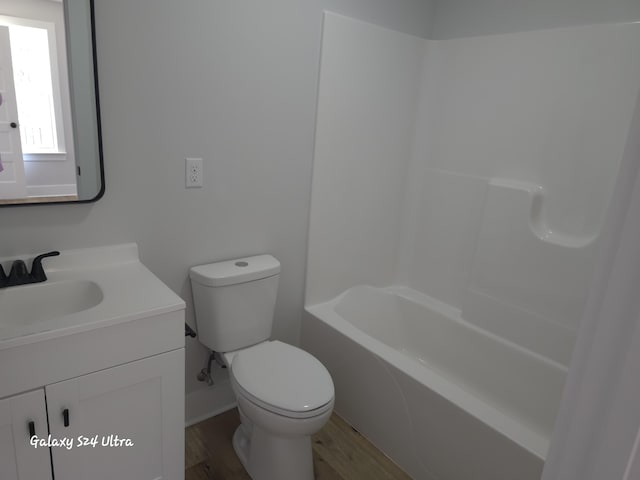 full bathroom featuring vanity, hardwood / wood-style flooring, bathing tub / shower combination, and toilet