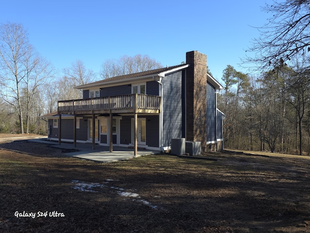 rear view of property with a patio, a wooden deck, and central AC unit