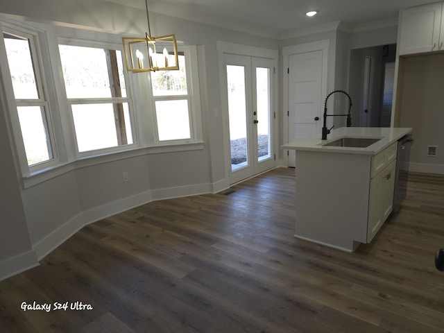 kitchen featuring pendant lighting, white cabinetry, an island with sink, sink, and dark wood-type flooring