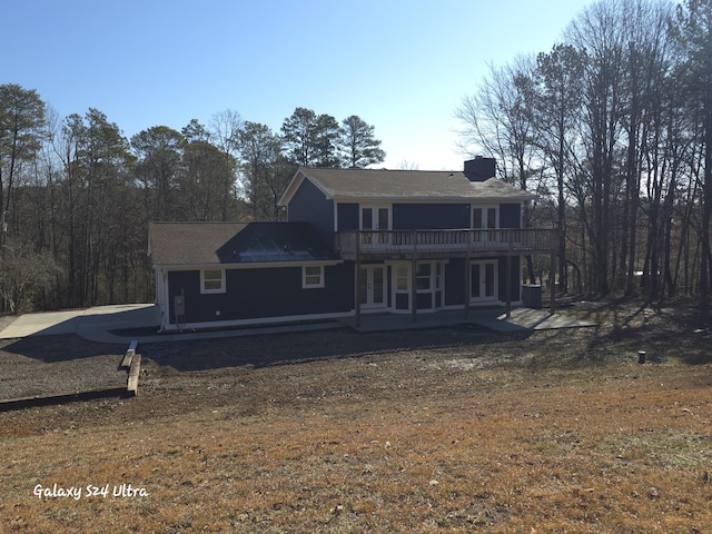 back of house featuring a lawn and a patio