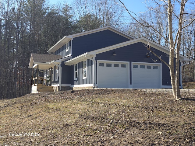 view of side of property with a porch and a garage