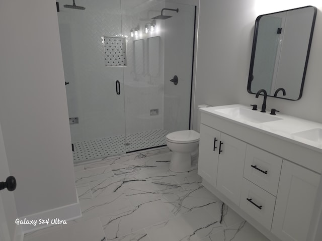 bathroom featuring vanity, a shower with shower door, and toilet