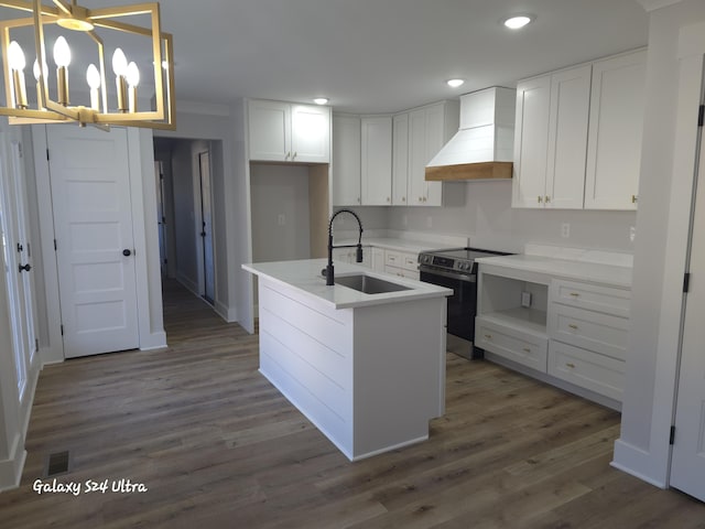 kitchen with white cabinetry, hanging light fixtures, electric range, a center island with sink, and custom exhaust hood