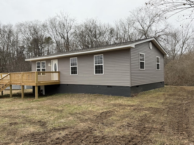 rear view of house with a deck and a lawn