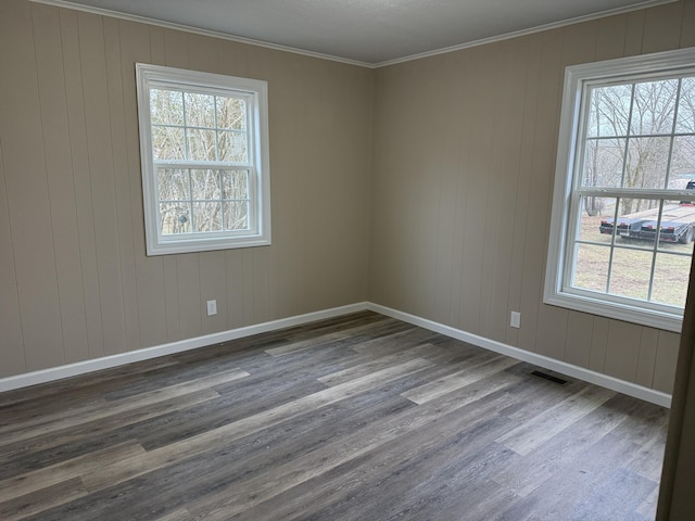 spare room featuring hardwood / wood-style floors, plenty of natural light, and ornamental molding