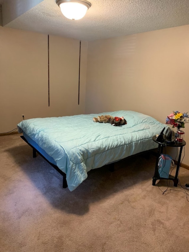 bedroom featuring carpet and a textured ceiling