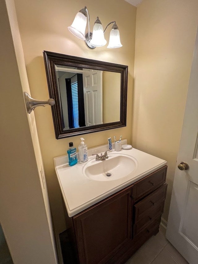 bathroom with tile patterned flooring, vanity, and a notable chandelier