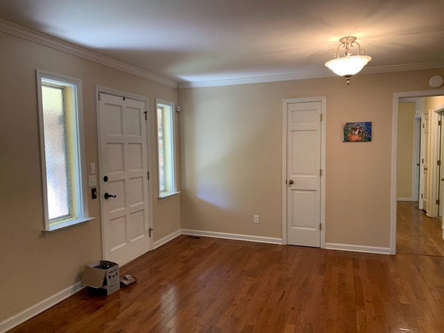 entrance foyer with ornamental molding, a healthy amount of sunlight, and hardwood / wood-style flooring