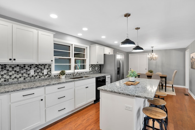 kitchen featuring a kitchen island, white cabinetry, and sink