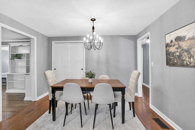 dining room featuring hardwood / wood-style flooring and a notable chandelier