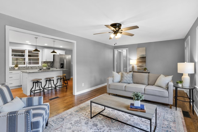 living room featuring ceiling fan and light hardwood / wood-style floors