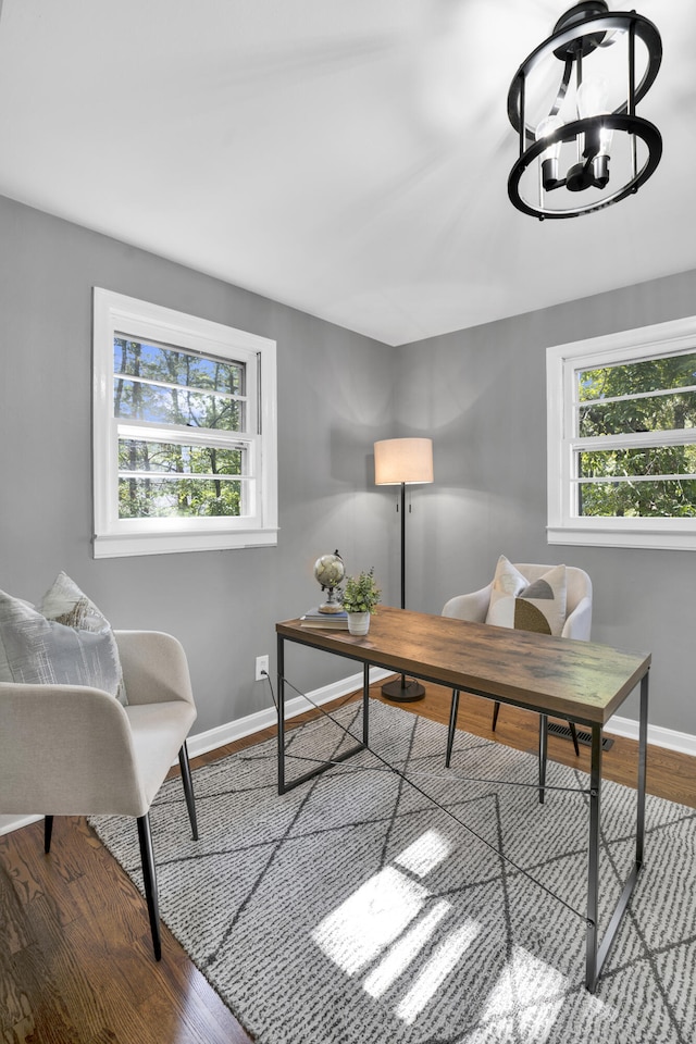 office space featuring wood-type flooring and a chandelier