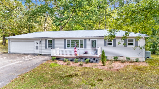 ranch-style home with a front yard, central AC unit, and a garage