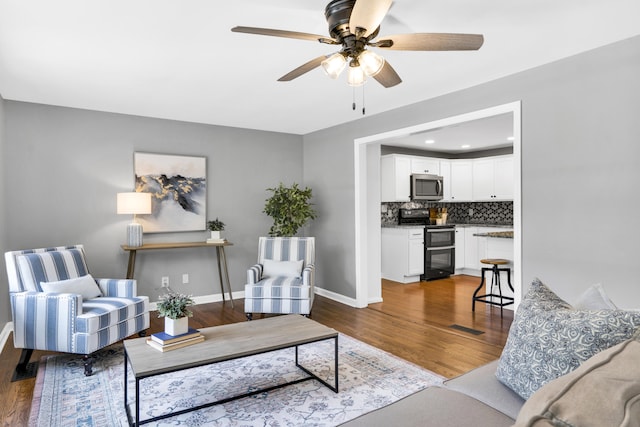 living room with ceiling fan and wood-type flooring